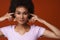 Black young woman wearing rings plugging her ears