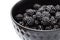 Blackberries in a black bowl, ripe fresh berries macro photo