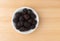 Blackberries in a bowl on a wood table