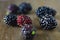 Blackberries fruits under wood macro view