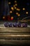 Blackberries in a row on a barn wood board with lights in the background