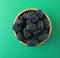 Blackberries in a wooden bowl. Ripe and tasty black berry isolated on green baclground