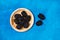 Blackberries on a wooden plate on a textured classic blue background