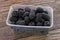 Blackberry fruit in plastic bowl on wooden background