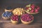 Blackberry, strawberry, yellow and red raspberries, dogwood in wooden bowls.