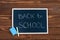 Blackboard with Back to School text, chalk and sponge on a wooden background. Concept start of the school year and sale