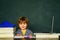 Blackboard background - copy space. School or college pupil showing parents a test with good grade. Education first. Boy