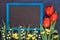 Blackboard in blue frame with red tulips and lily of the valley