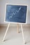 Blackboard easel for drawing with chalk on which an up arrow is shown as an increase in monetary profit