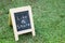 Blackboard with easel and wording like and share on green grass