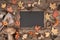 Blackboard framed with Autumn decorations on wood, space