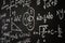 Blackboard inscribed with scientific formulas and calculations in physics, mathematics and electrical circuits. Science and