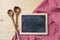 Blackboard and kitchen utensils on red tablecloth, wooden table, space for text, top view