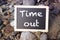 Blackboard lying between stones with the words Time Out