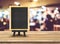 Blackboard menu with easel on wooden table with blur restaurant