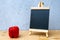 Blackboard and red bell pepper on wooden table with grey background