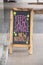 Blackboard sandwich board sign  on sidewalk outside clothing store in neon colors announcing new arrivals - Selective focus