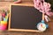 Blackboard, stationery, alarm clock and flowers on wooden table, flat lay with space for text. Teacher`s Day