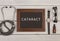 blackboard with text & x22;Cataract& x22;, stethoscope, eyeglasses and watch