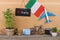 blackboard with text & x22;Italy& x22;, flag of the Italy, airplane model, little bicycle and suitcase, camera, compass