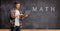 Blackboard with text math and formulas and a male student with laptop computer