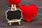 Blackboard on wooden background with red heart. Copy space