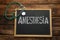 Blackboard with word Anesthesia and stethoscope on wooden table, top view