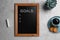 Blackboard with word GOALS and empty checklist on light grey stone background, flat lay