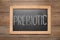 Blackboard with word Prebiotic on wooden table, top view