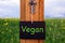 Blackboard with word Vegan hanging on key in front of field
