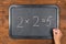 Blackboard with wrong maths equation and chalk in hand