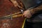 Blacksmith fastens leather winding of sword