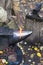 Blacksmith forges red glowing iron rod on anvil