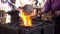 Blacksmith furnace with a hot iron, burning embers and sparks in slowmotion.