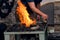 Blacksmith handles pig iron in a blacksmith`s forge.