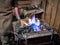 Blacksmith heats the iron on the furnace fire