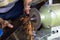 Blacksmith`s hands sharpening a carpenter`s saw using a bench grinder