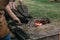 Blacksmiths poking burning coals in furnace and squeezing bellows to kindle fire