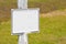 Blank advertising white metal billboard in a field of dried grass - image with copy space