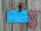 Blank antique blue sign with red hearts and iron keys hanging on shabby wooden background