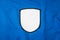 Blank arm patch on blue sport shirt. White team logo and emblem for your montage or edit