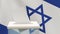 Blank ballot with space for text or logo is dropped into the ballot box against the backdrop of the flag of Israel. Election
