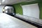 Blank billboard on green subway wall and mooving train