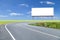 Blank billboard for your advertisement with space for text on road curve,with green grass and blue sky white cloud.