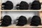 Blank black caps on wooden rack in store