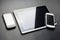 Blank Black Mobile Lying Next To A Business Tablet With Reflection And A White Smartphone On It\'s Corner, All Above A Carbon Layer