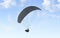 Blank black paraglider with person in harness mockup, sky background