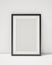 Blank black picture frame on the white interior background