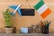 blank blackboard, flag of the Ireland, airplane model, little bicycle and suitcase, compass, pencils