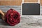 blank blackboard hang on the rope with dry red rose